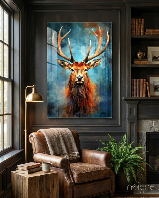 Red stag antlers teal watercolor glass art displayed on dark paneled wall above leather chair in library room setting.