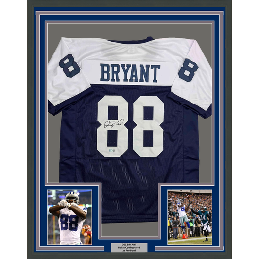 Framed dark navy and white Dallas Cowboys jersey number 88 signed by Dez Bryant, displayed with two action photos and nameplate plaque.