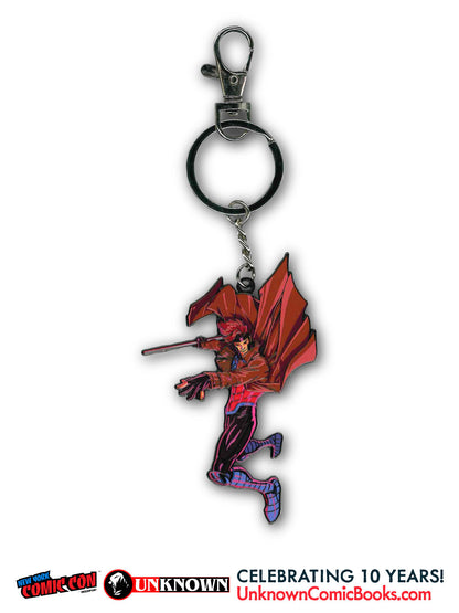 Front view of a metal keychain with a red, black and purple figure in a red coat holding a staff.