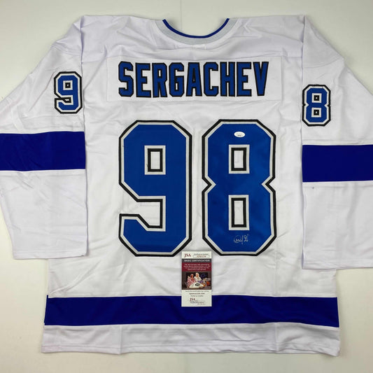 White and blue Tampa Bay Lightning hockey jersey with "SERGACHEV" and number 98 printed on back, displayed flat with JSA authentication certificate visible below neckline.