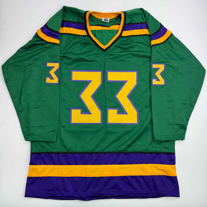 Green hockey jersey with yellow number 33 outlined in purple, displayed flat against white background showing front view.