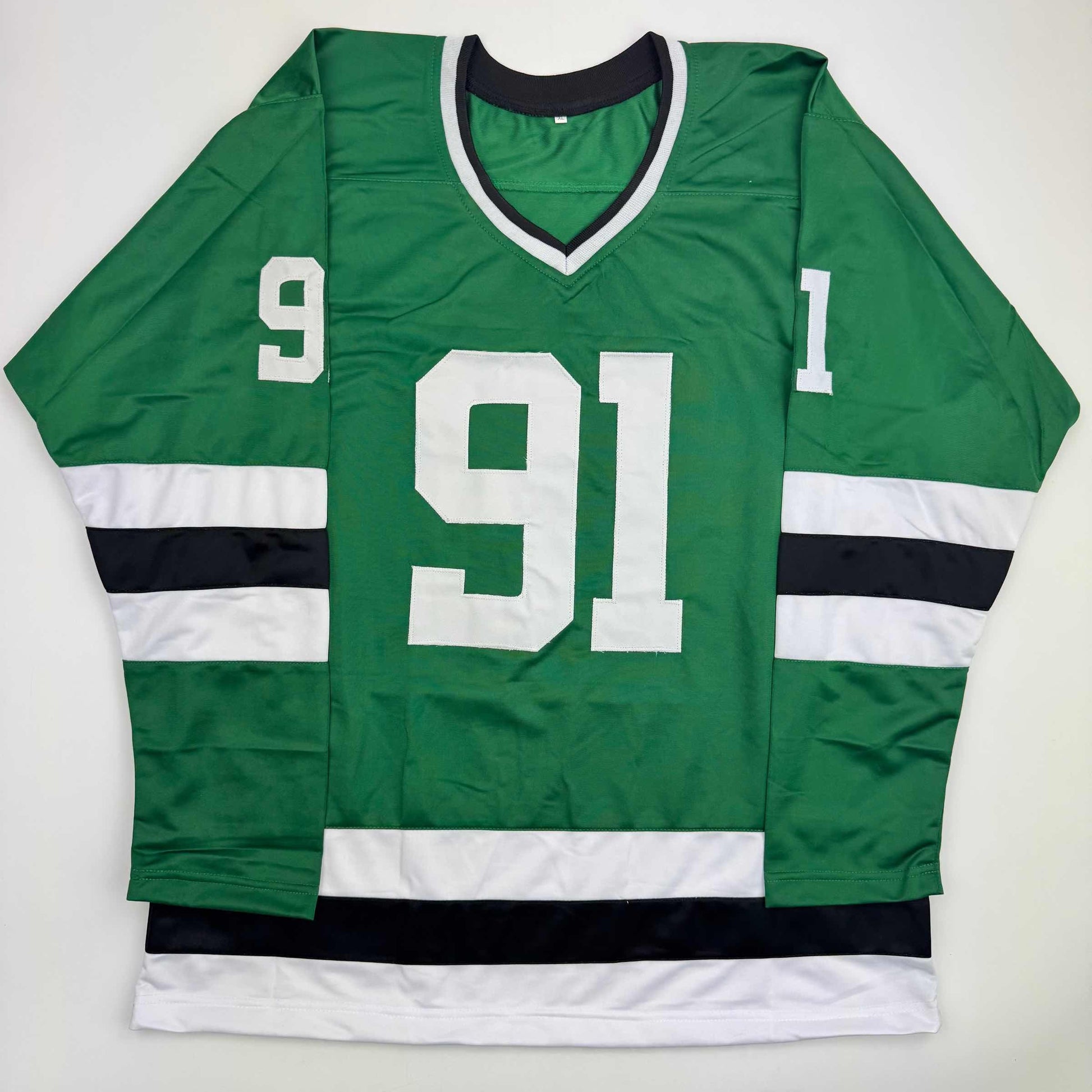 Green and black hockey jersey with white stripes and number 91 displayed flat against white background.