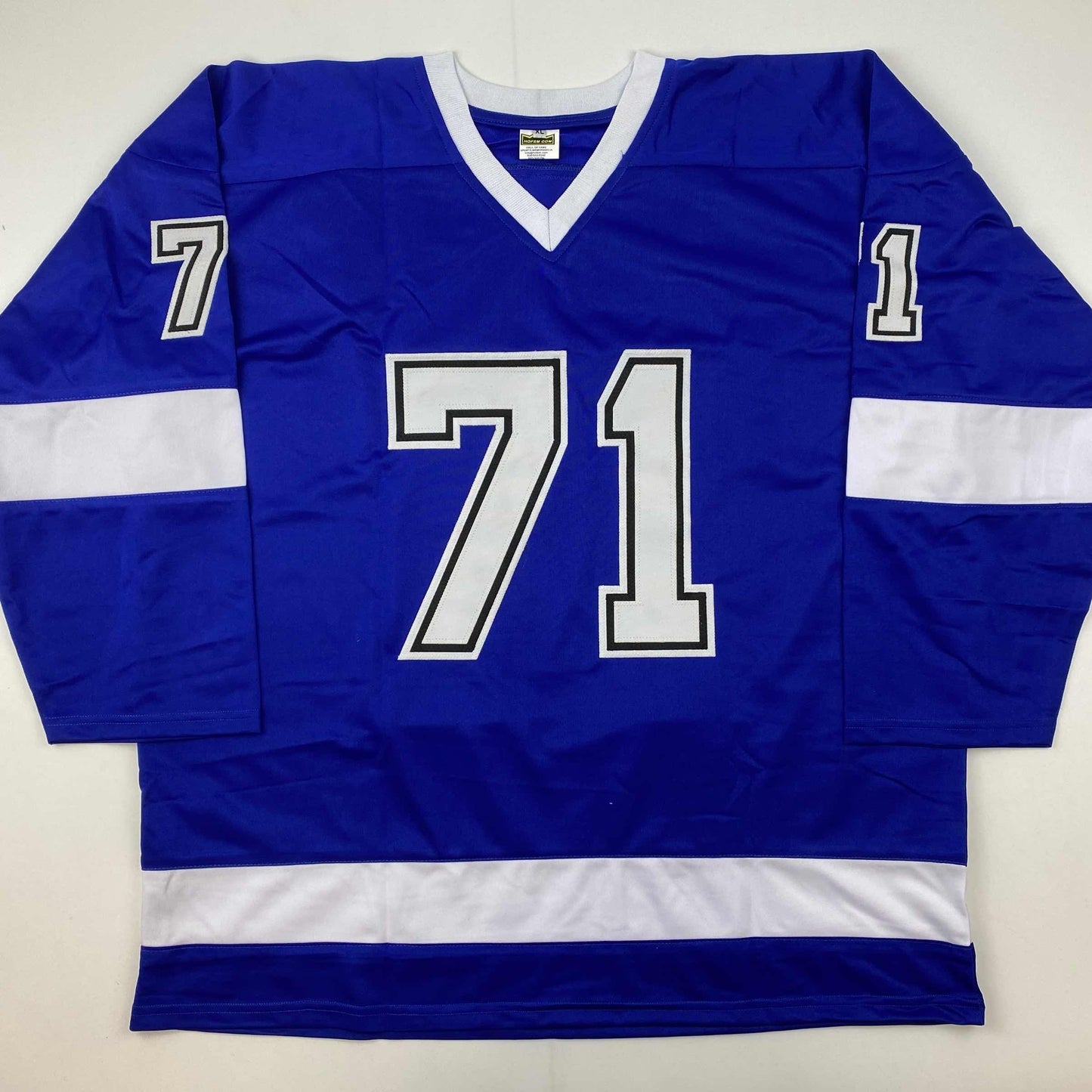 Blue hockey jersey with white trim and number 71 displayed flat against white background, front view.