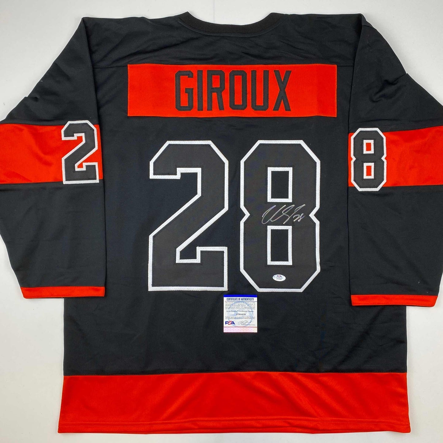 Back view of black and red hockey jersey with "GIROUX" and number "28" in white outlined numerals, signed in silver marker, with PSA/DNA authentication certificate at bottom.