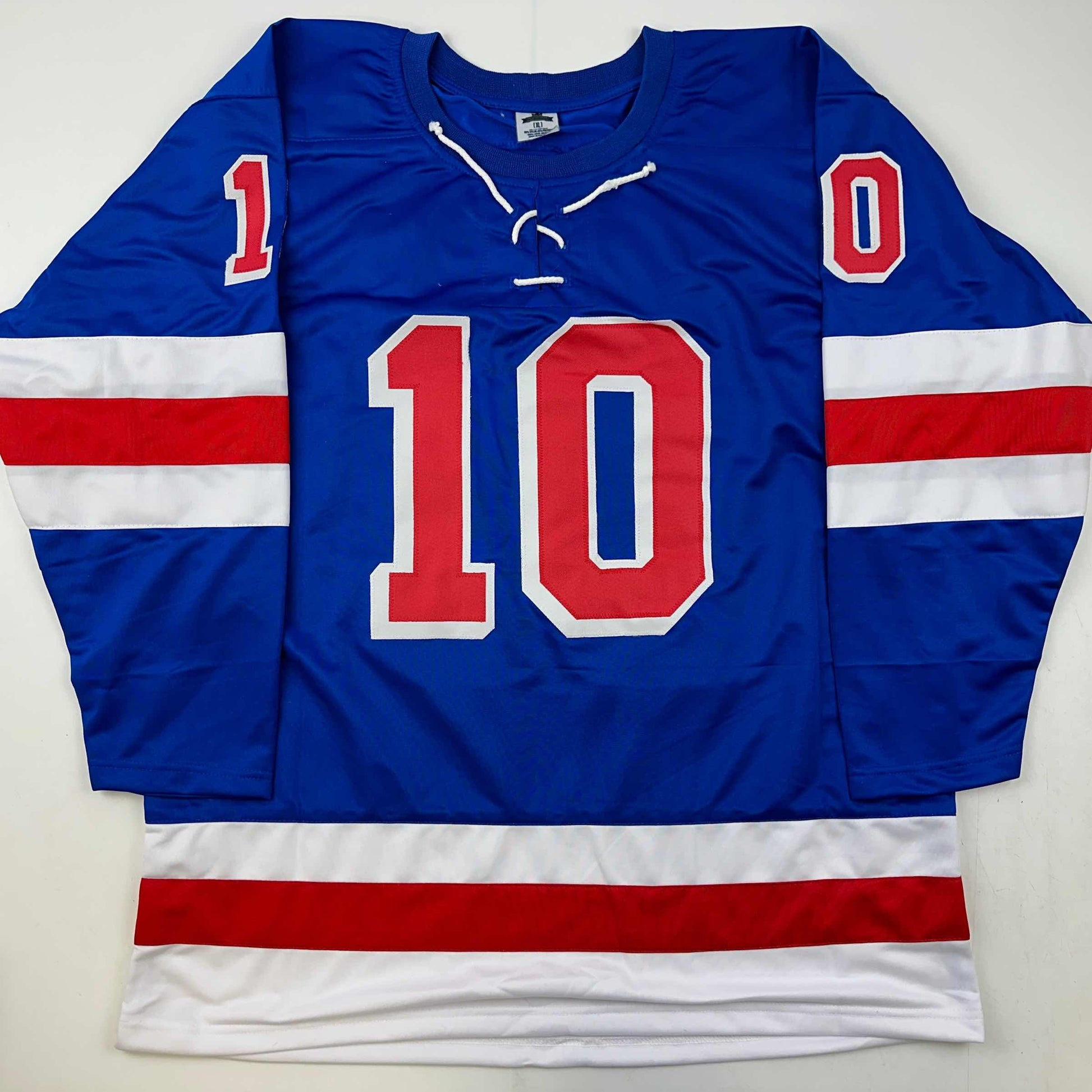 Blue hockey jersey with red number 10 and red-white-blue striped sleeves, displayed flat against white background.