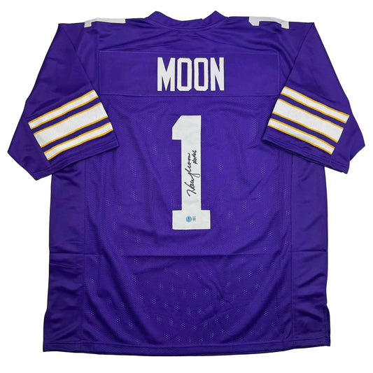 Purple Minnesota Vikings football jersey number 1 signed by Warren Moon, displayed flat showing back with name and number visible.