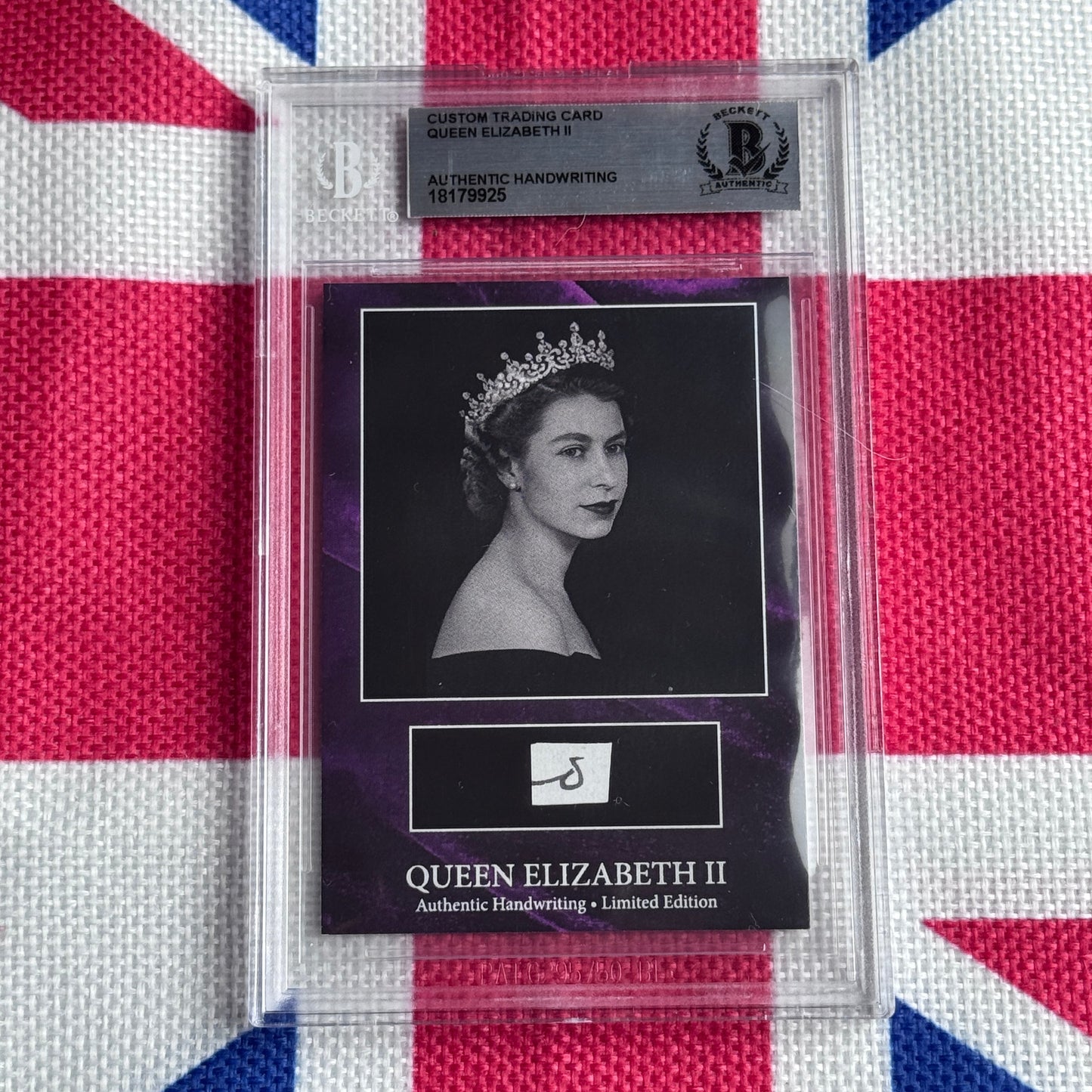 Sealed trading card featuring black and white portrait of Queen Elizabeth II wearing tiara, with authentication label and Union Jack fabric background.