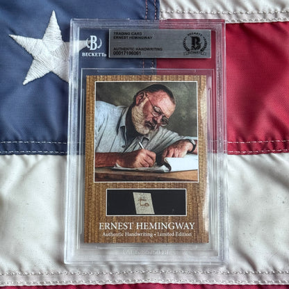Beckett authenticated Ernest Hemingway trading card with handwriting sample displayed on American flag background, showing portrait and certification details.