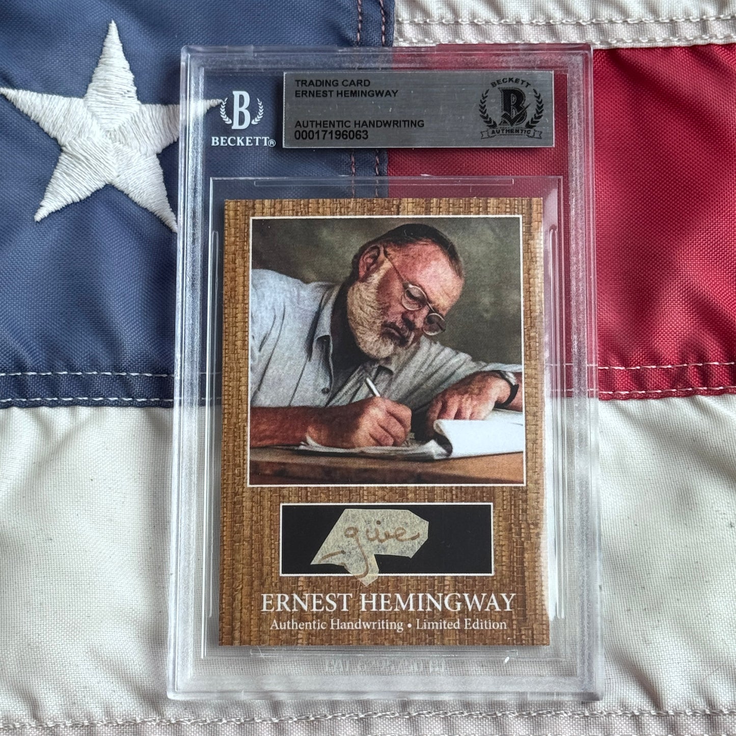 Beckett-authenticated Ernest Hemingway trading card with handwritten signature displayed against American flag backdrop.