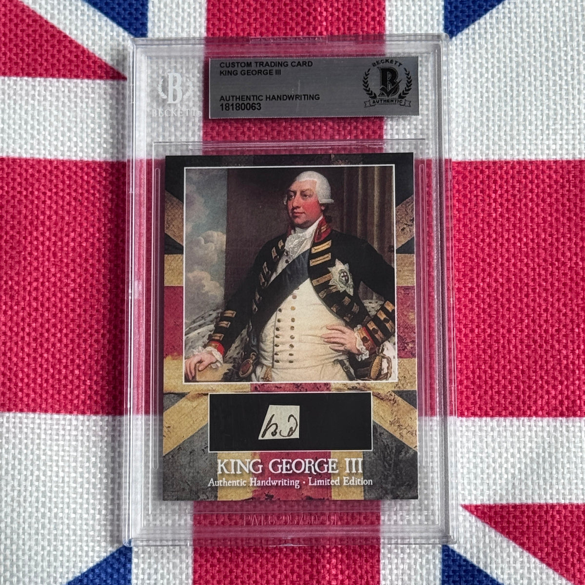 Custom trading card of King George III with authentic handwriting sample and portrait, displayed in protective plastic case against Union Jack background.