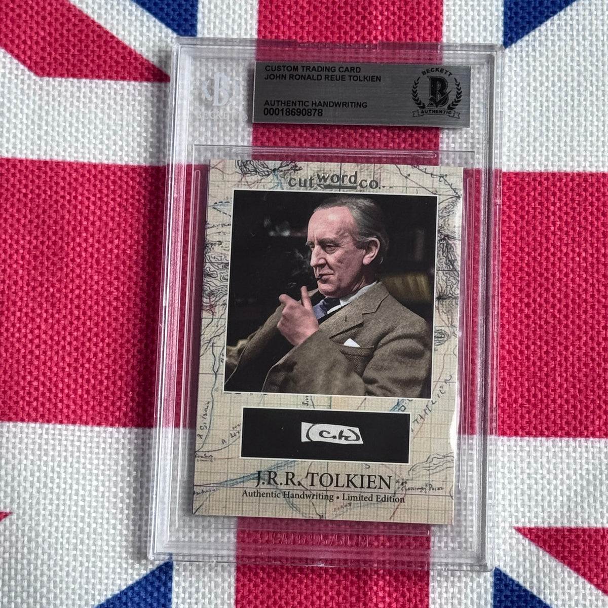 Custom trading card with authenticated J.R.R. Tolkien handwriting sample, displayed in protective case against Union Jack background.