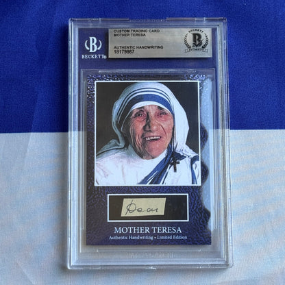 Beckett-graded trading card featuring Mother Teresa's photograph and authentic handwritten signature beneath, displayed in clear protective case against blue background.
