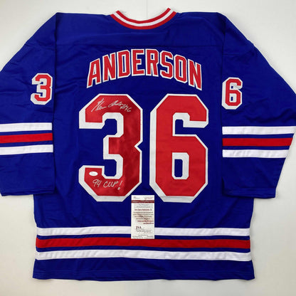 Back view of blue hockey jersey numbered 36 with "Anderson" nameplate, red and white striped sleeves, signed in black ink with "94 Cup" notation and JSA authentication certificate attached.