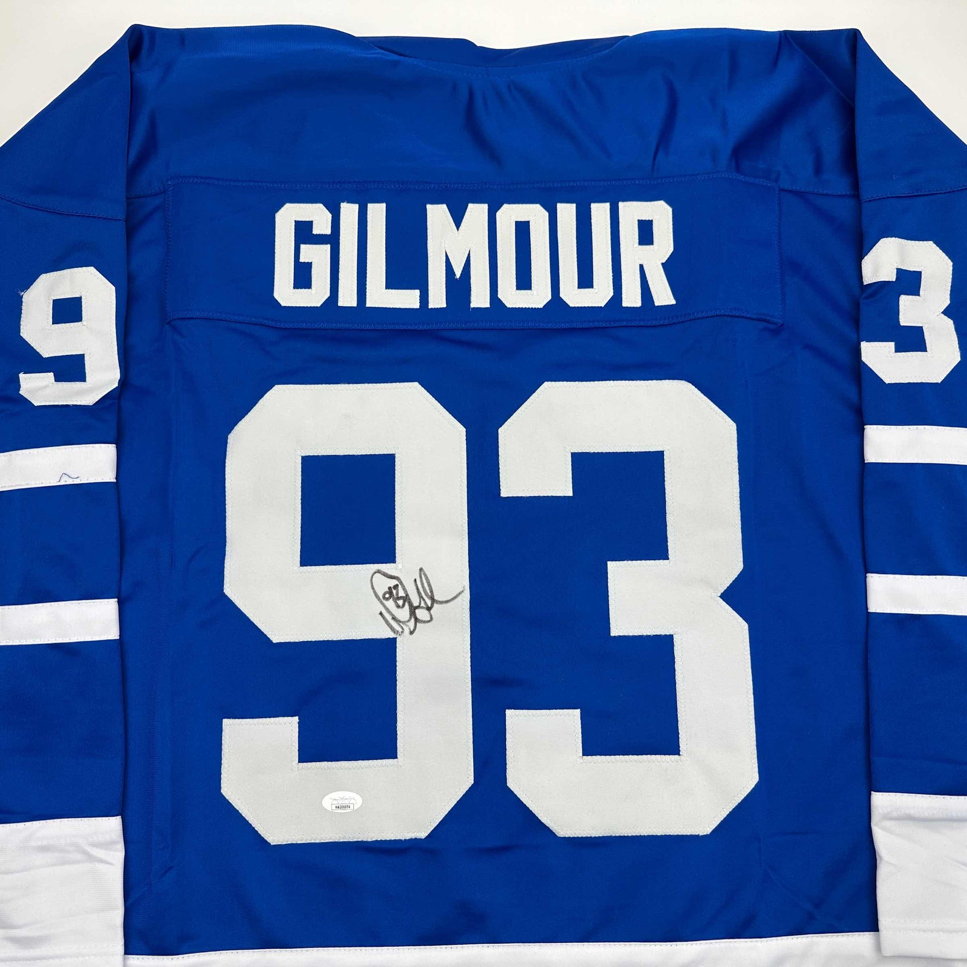 Blue Toronto Maple Leafs hockey jersey displaying "GILMOUR" and number 93 with autographed signature on front.