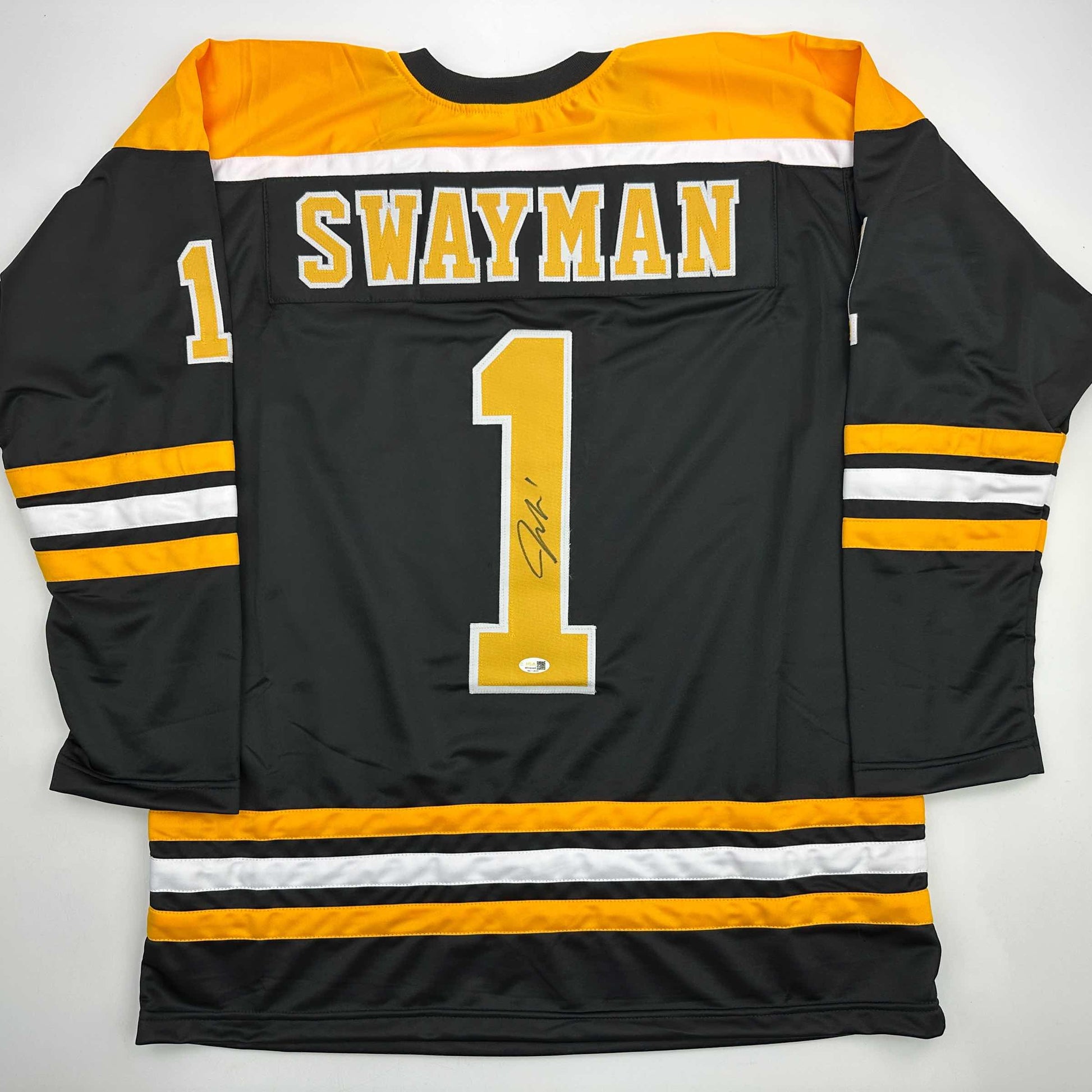 Back view of black hockey jersey with yellow and white stripes, "SWAYMAN" and number "1" with signature visible.