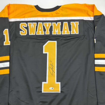 Back view of black and gold hockey jersey with "SWAYMAN" and number 1 in yellow and white with autograph on number.