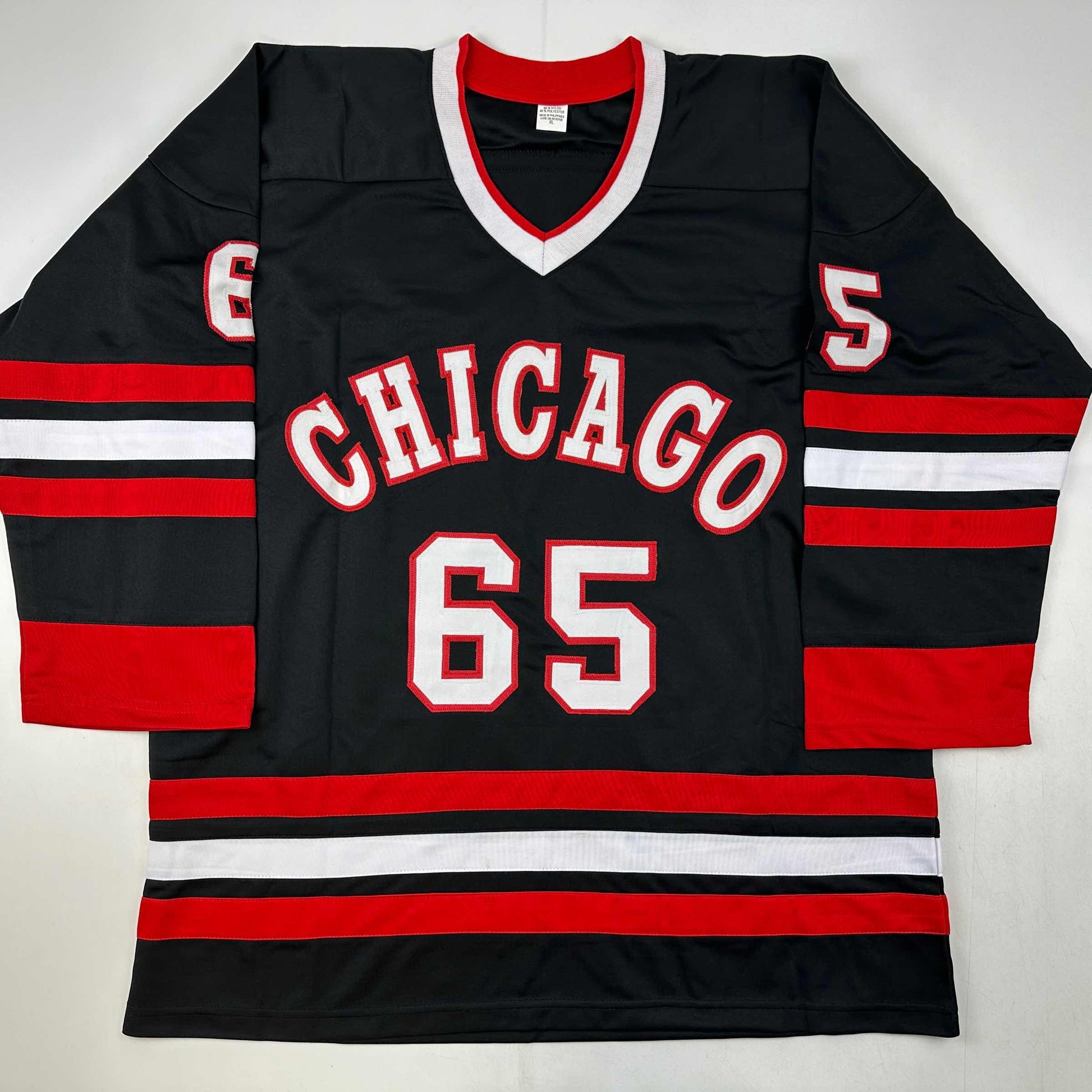 Black Chicago hockey jersey with red and white horizontal stripes, number 65, displayed flat against white background.