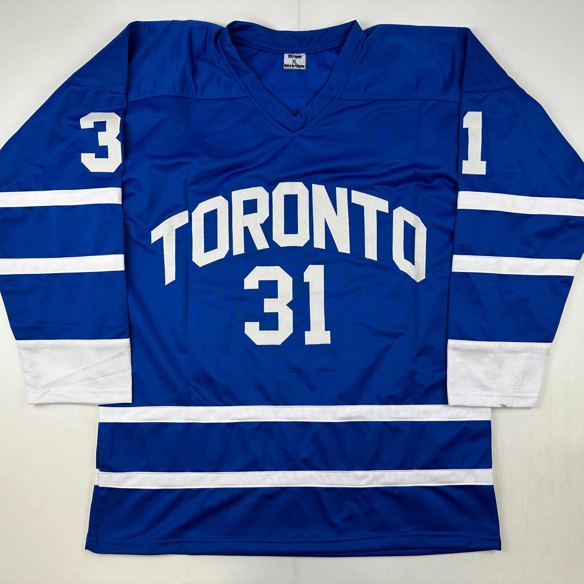 Blue Toronto hockey jersey displayed flat showing front and sleeves with white "TORONTO 31" text and striping.