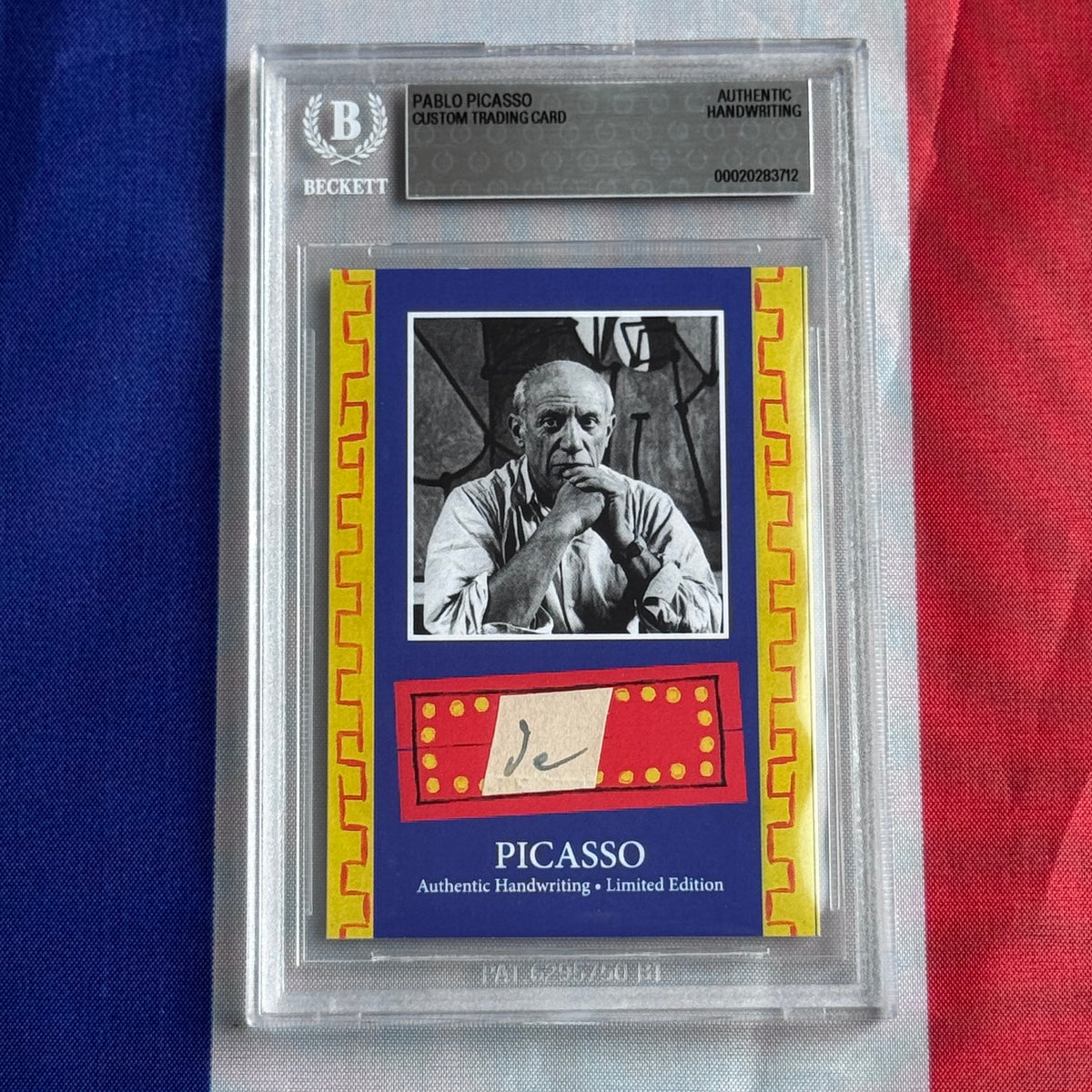 Front view of a Beckett-sealed slab holding a card with a black-and-white portrait and a handwritten signature on red.