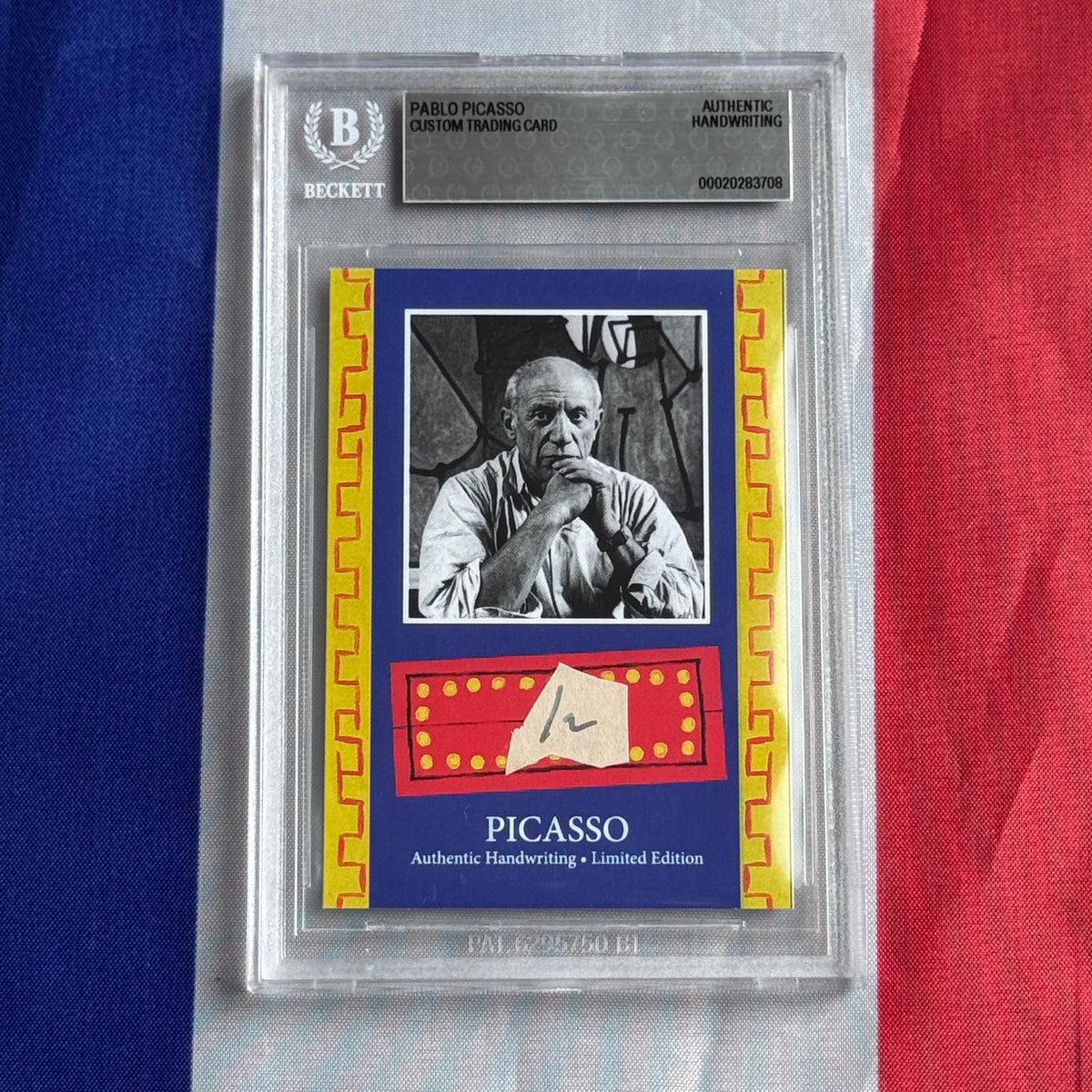 Front view of a graded card in a clear slab, showing a black-and-white portrait photo, blue border and PICASSO lettering.