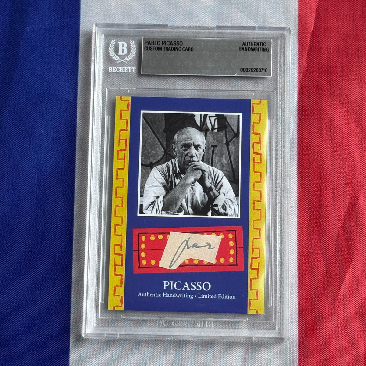 Front of a Beckett-slabbed card: black-and-white portrait, signature on a cream slip, and PICASSO lettering on blue.