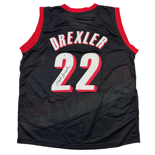 Back view of black Portland basketball jersey number 22 with red trim and "DREXLER" nameplate, signed in blue ink.