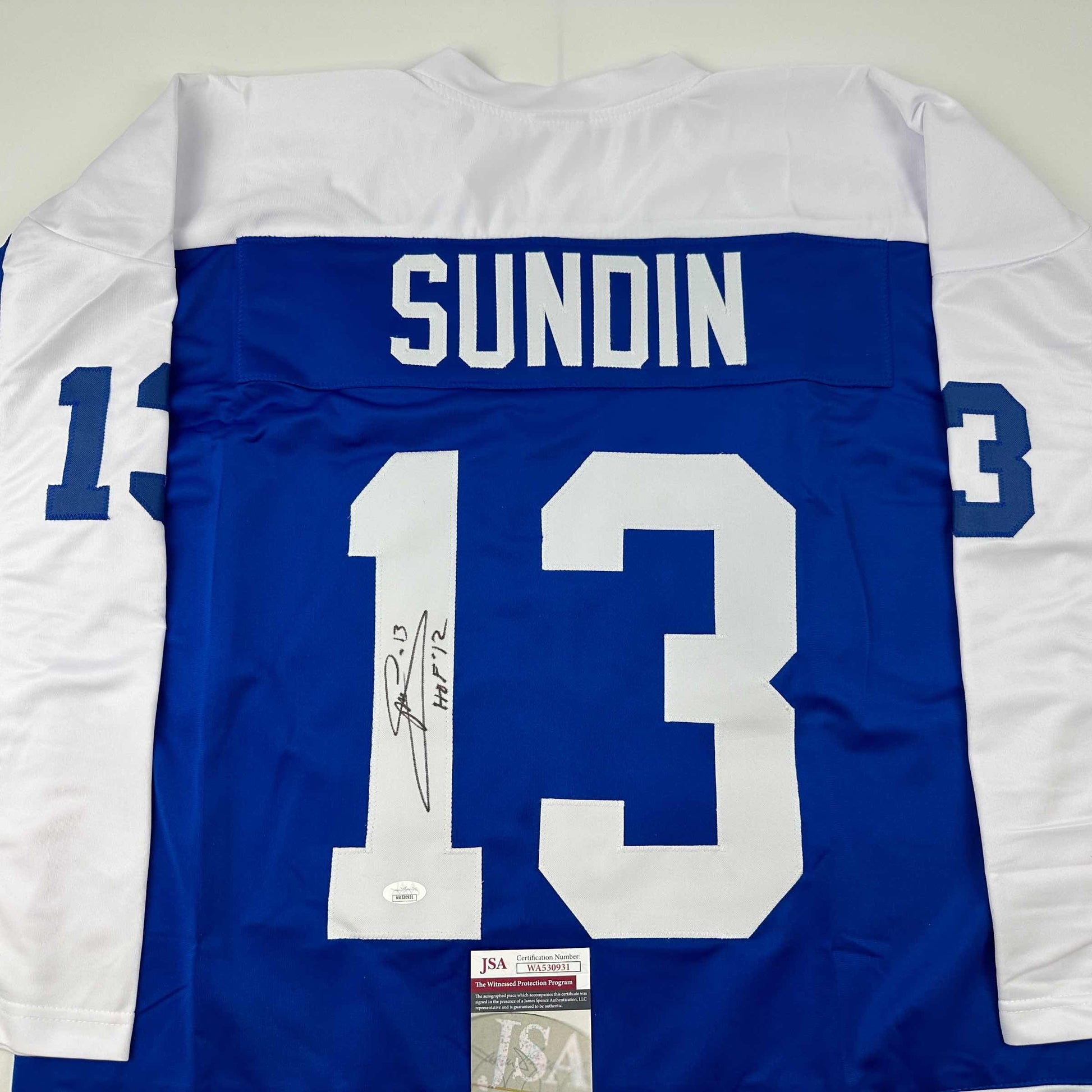 Back view of blue Toronto Blue Jays hockey jersey numbered 13 with "SUNDIN" nameplate and autographed signature, displaying JSA authentication certificate.