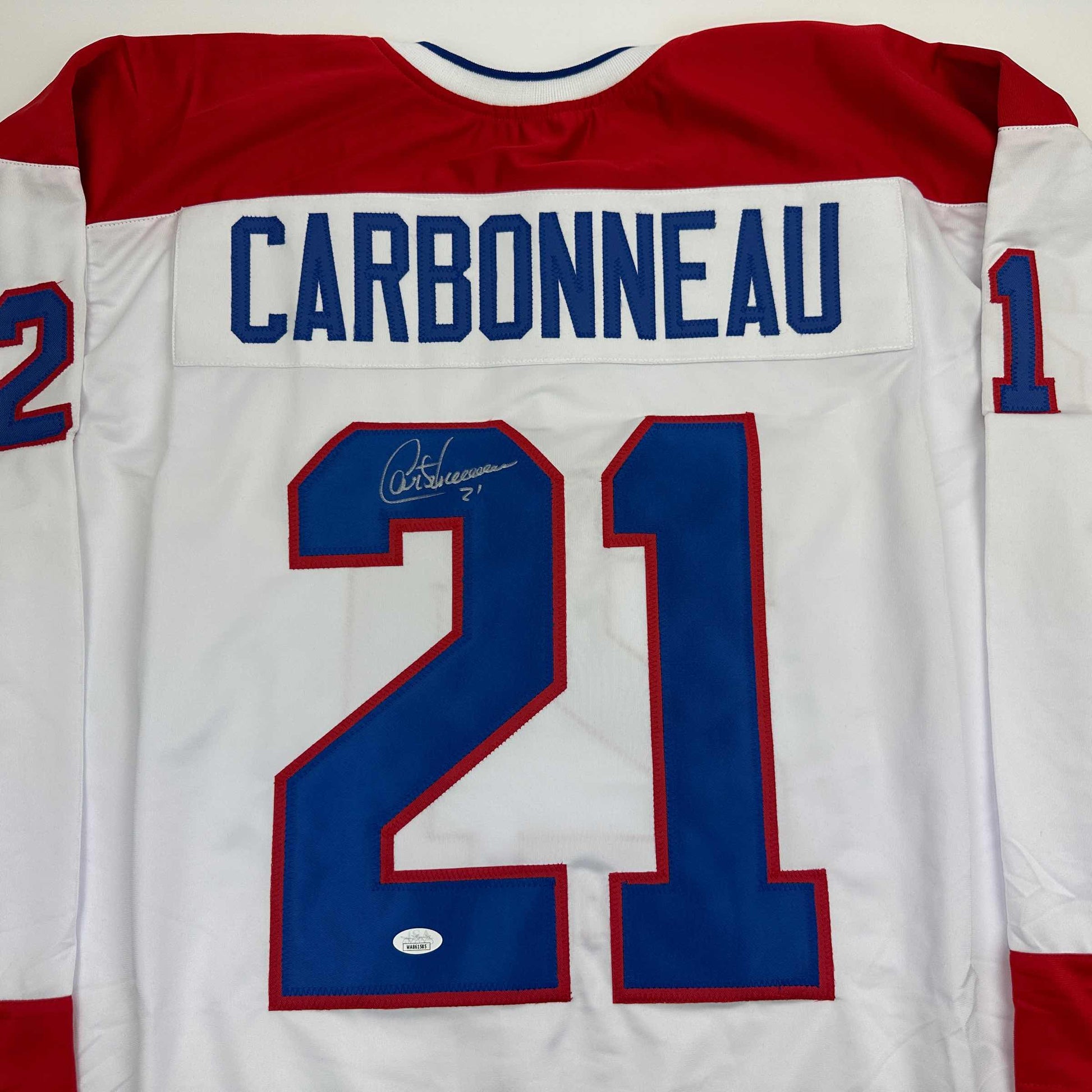 Back view of signed Montreal Canadiens white hockey jersey number 21 with Carbonneau nameplate.