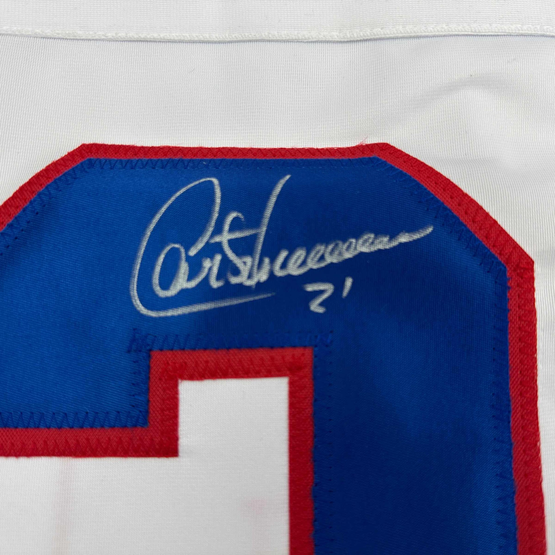 Close-up of autograph signed in silver pen on blue fabric of Montreal Canadiens hockey jersey with red trim.
