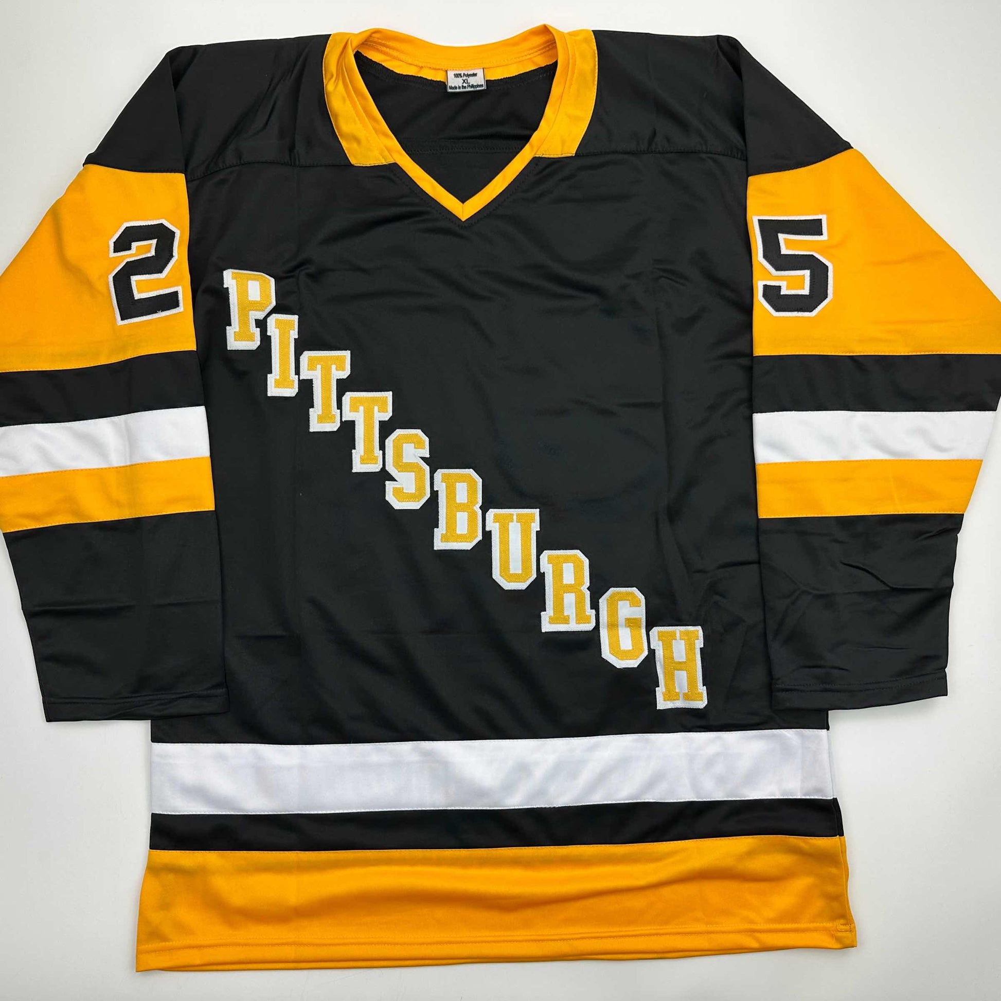 Pittsburgh Penguins black and gold hockey jersey with "PITTSBURGH" text diagonally across chest and numbers 2 and 5 on sleeves, displayed flat.