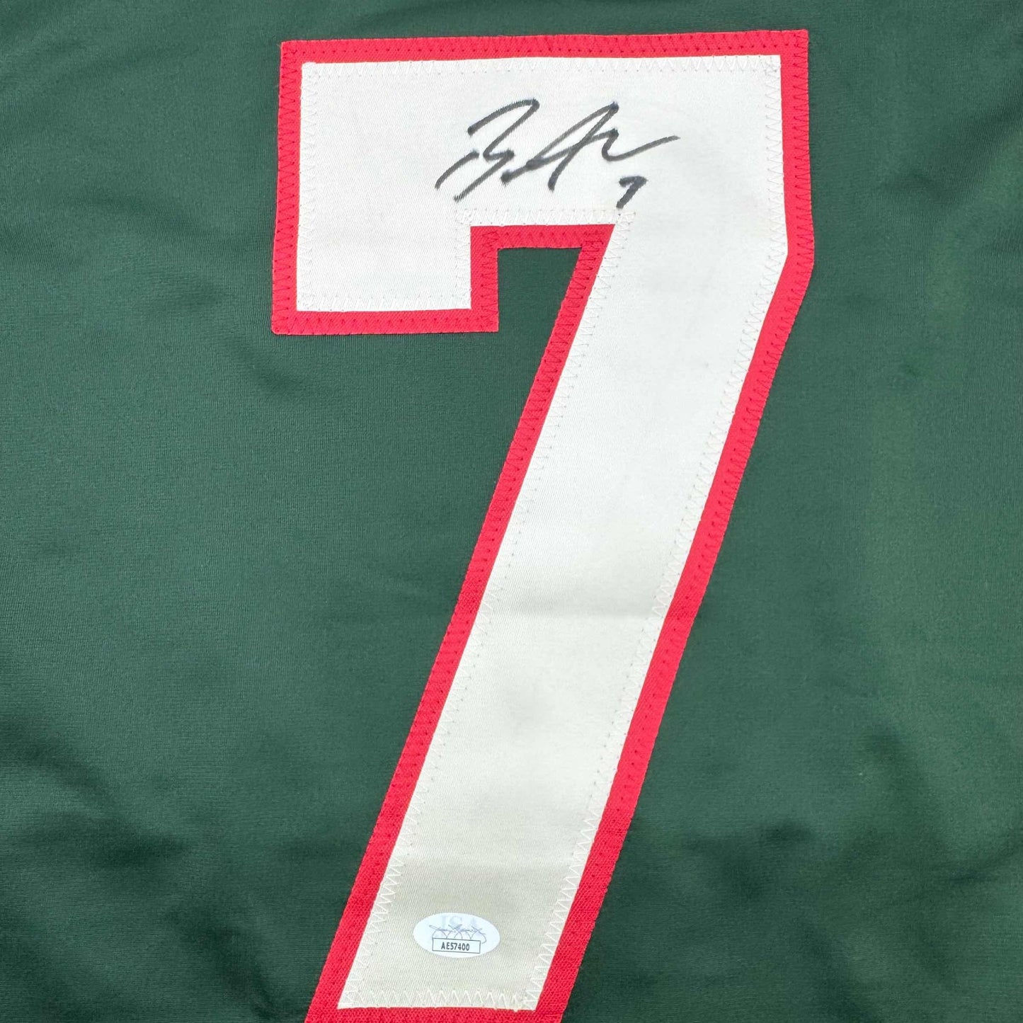Close-up of signed jersey number 7 with red and white coloring and JSA authentication sticker visible.