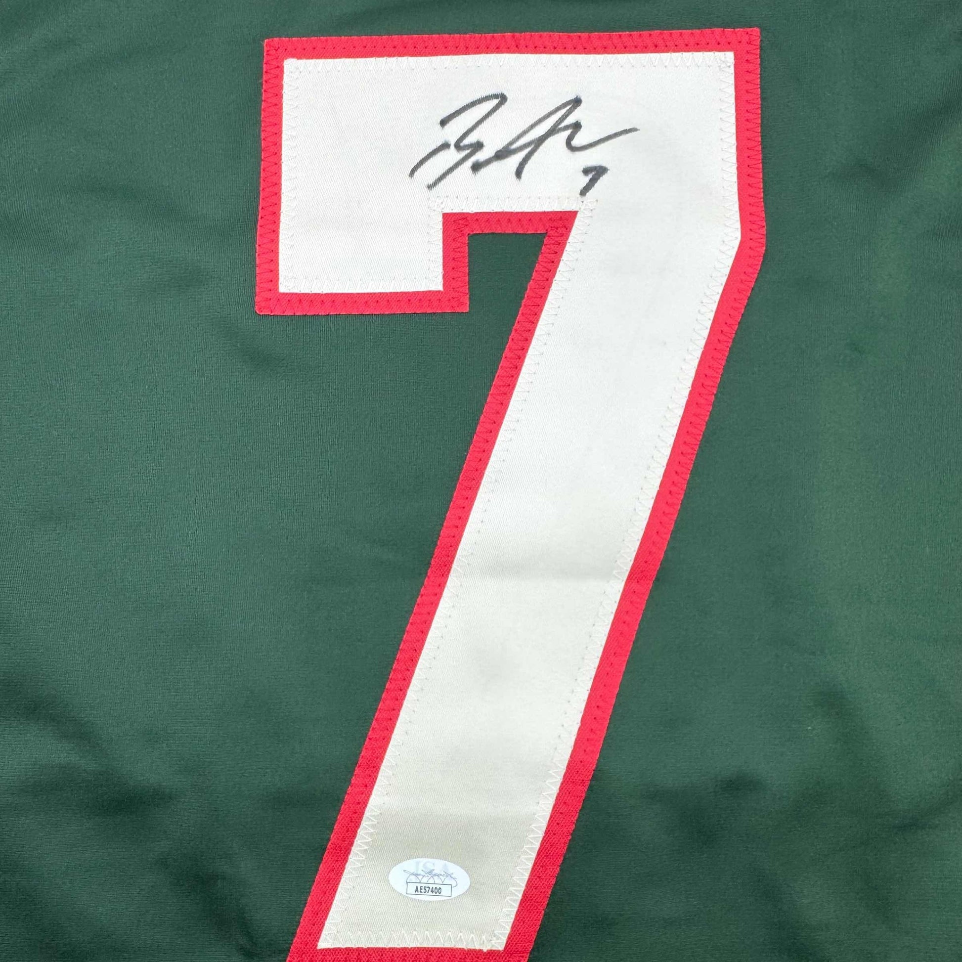 Close-up of signed jersey number 7 with red and white coloring and JSA authentication sticker visible.