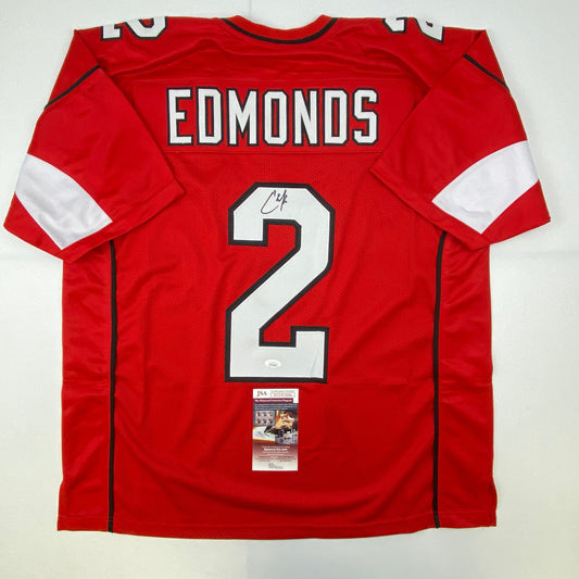 Red football jersey with "EDMONDS" and number 2 displayed, signed, shown flat lay with authentication certificate visible.