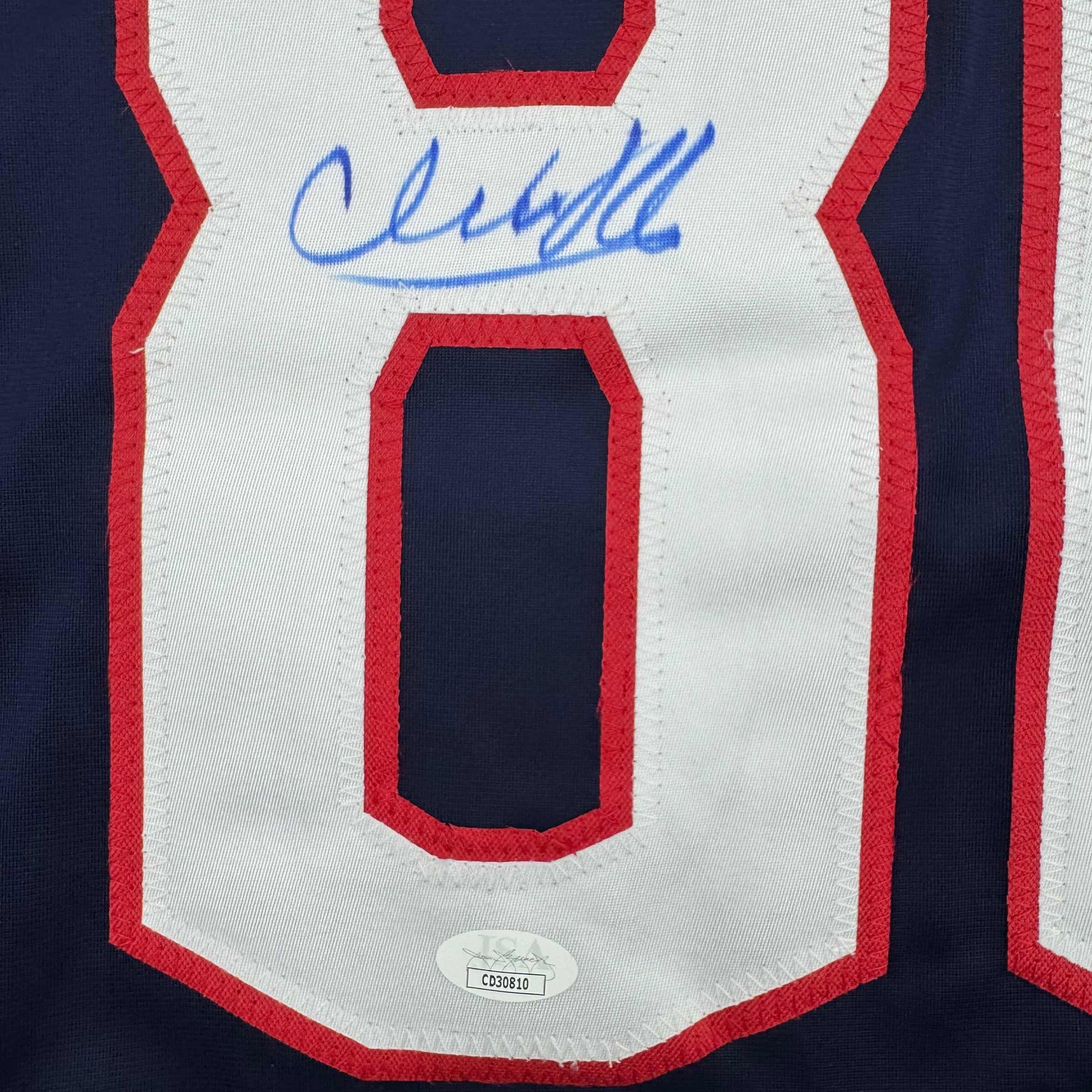 Close-up of signed Columbus Blue Jackets jersey front featuring red and white stripes with blue autograph and JSA authentication sticker.