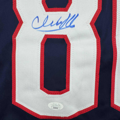 Close-up of signed Columbus Blue Jackets jersey front featuring red and white stripes with blue autograph and JSA authentication sticker.