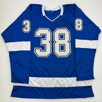 Blue and white striped hockey jersey displayed flat, showing number 38 on chest and numbers 3 and 8 on sleeves.