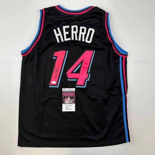 Back view of black Miami Heat Vice City jersey number 14 with "HERRO" nameplate, pink numerals, blue and pink trim, and JSA authenticity certificate attached.
