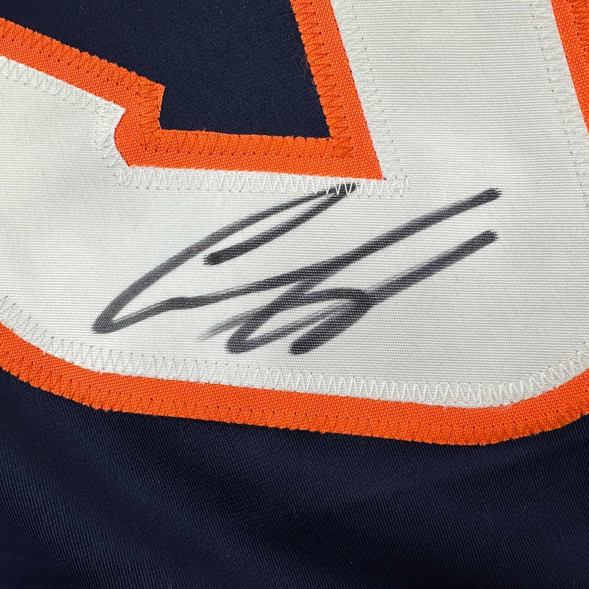 Close-up of signed Ilya Sorokin hockey jersey showing autographed initials in black ink on white fabric with orange and navy trim.