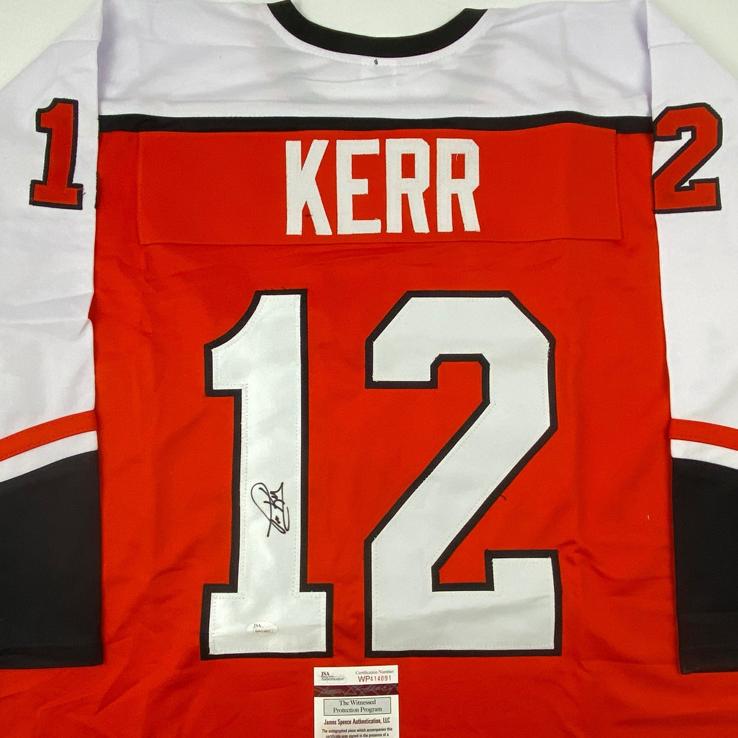 Red Philadelphia hockey jersey number 12 with "KERR" nameplate, signed, displayed flat with JSA authentication label visible at bottom.