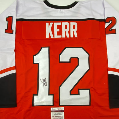 Red Philadelphia hockey jersey number 12 with "KERR" nameplate, signed, displayed flat with JSA authentication label visible at bottom.