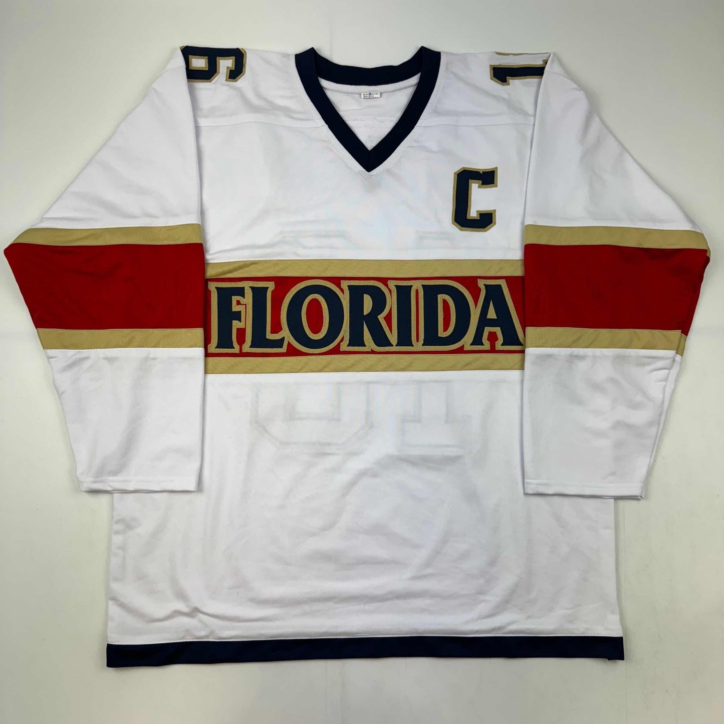 White Florida hockey jersey with red and gold horizontal stripes, displayed flat against gray background, front view.