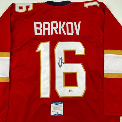Red Florida hockey jersey with "BARKOV" and number "16" displayed on back, featuring white and gold trim, with Beckett authentication certificate visible at bottom.