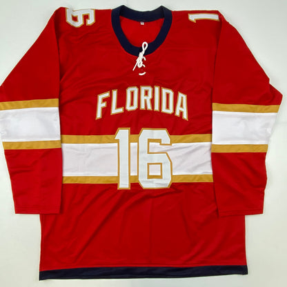 Red Florida hockey jersey number 16 displayed flat lay against white background, showing front with gold and white trim.