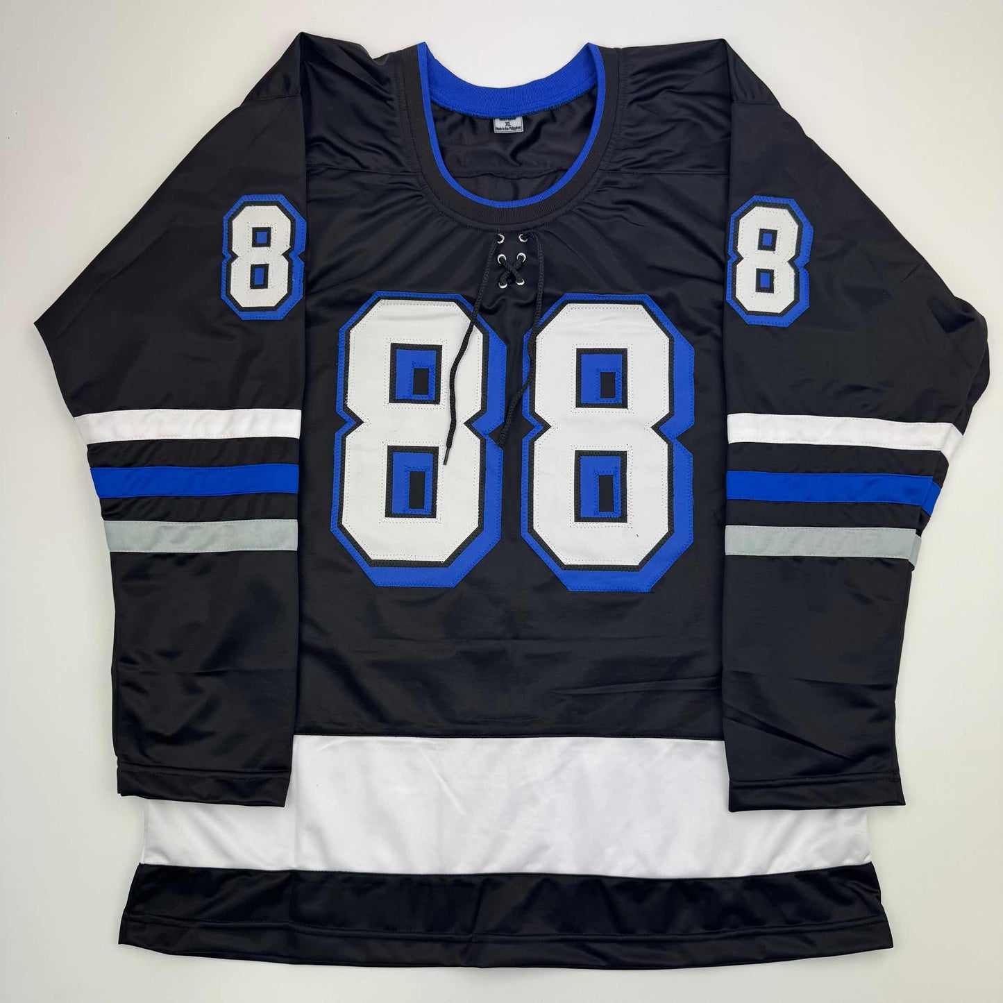 Black hockey jersey with blue and white trim displaying large number 88 on front and smaller number 8 on shoulders, flat lay view.