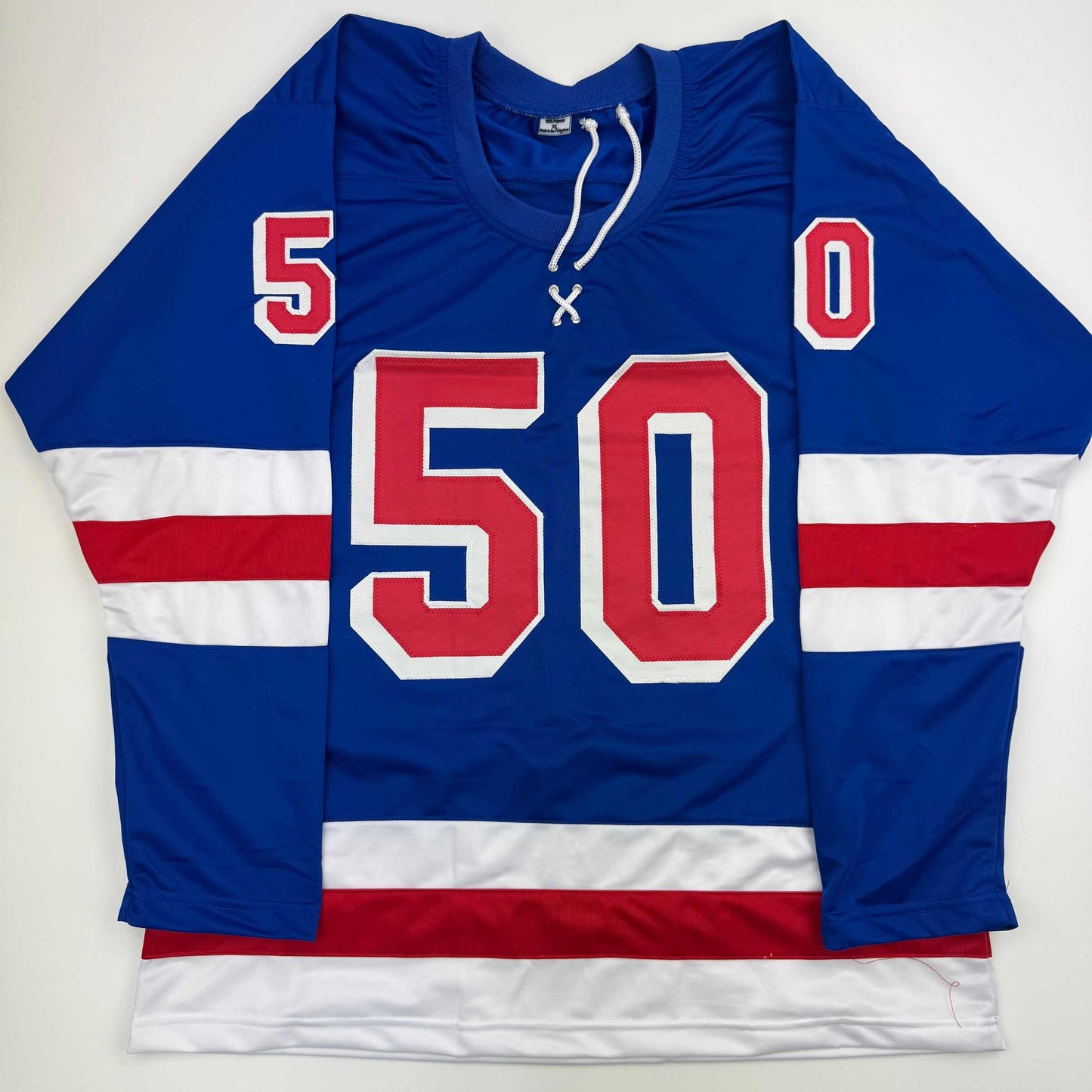 Blue, white, and red striped hockey jersey with large red number 50 and smaller numbers 5 and 0 on shoulders, displayed flat against white background.