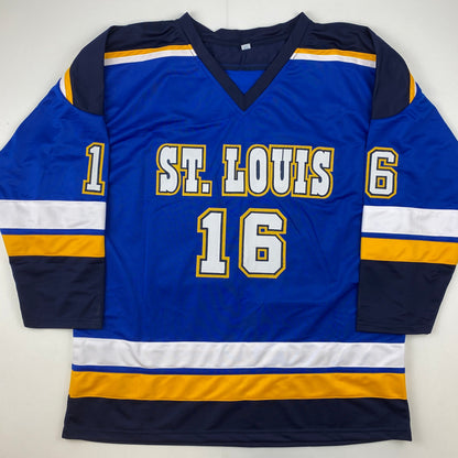 Blue St. Louis hockey jersey with white and gold lettering displaying "ST. LOUIS 16" on front, flat lay view against white background.