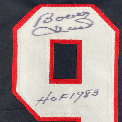 Close-up of signed jersey patch showing autographed number 9 in blue ink on red and white fabric.