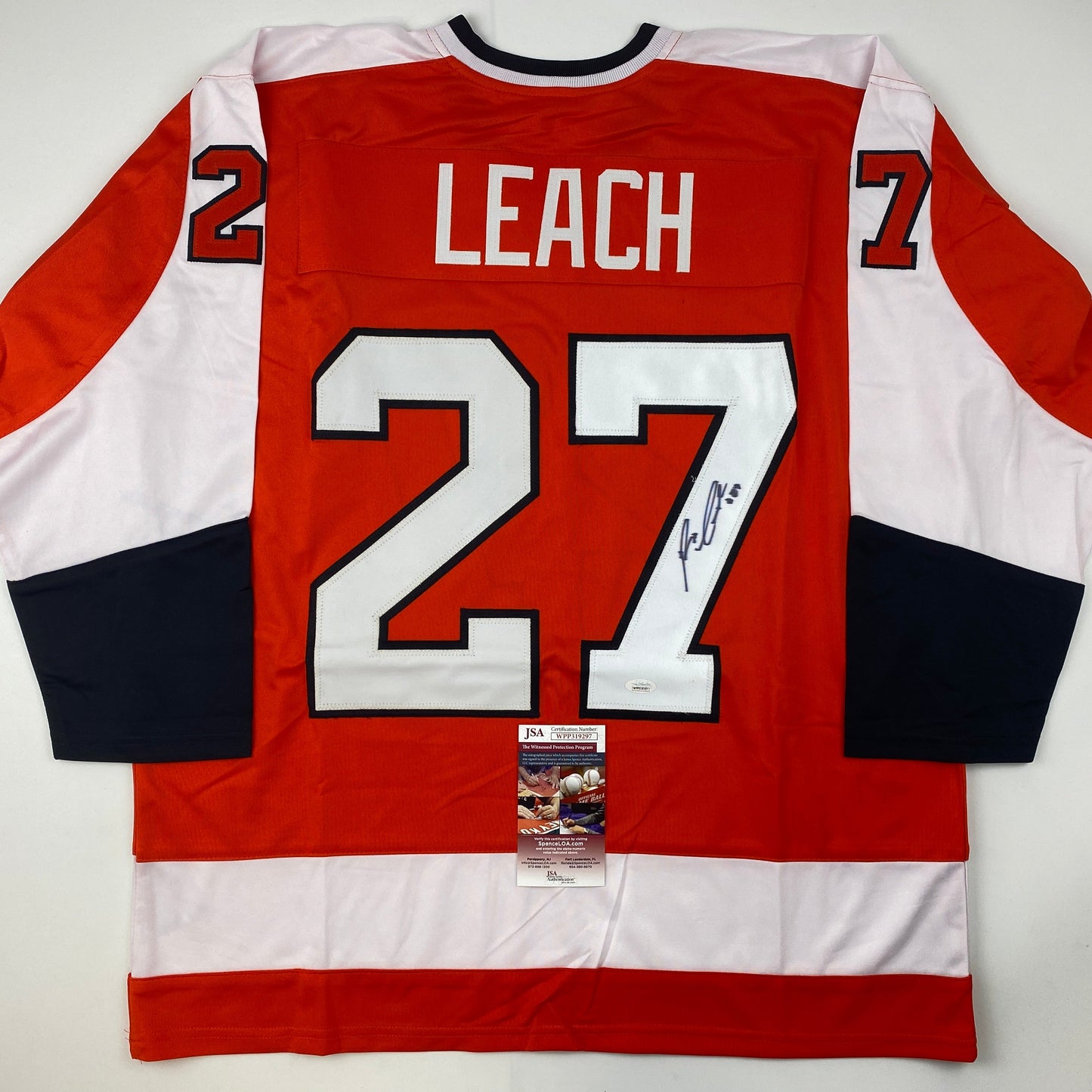 Back view of red, white, and black Philadelphia Flyers hockey jersey number 27 with "LEACH" nameplate and autograph, JSA authentication certificate attached.