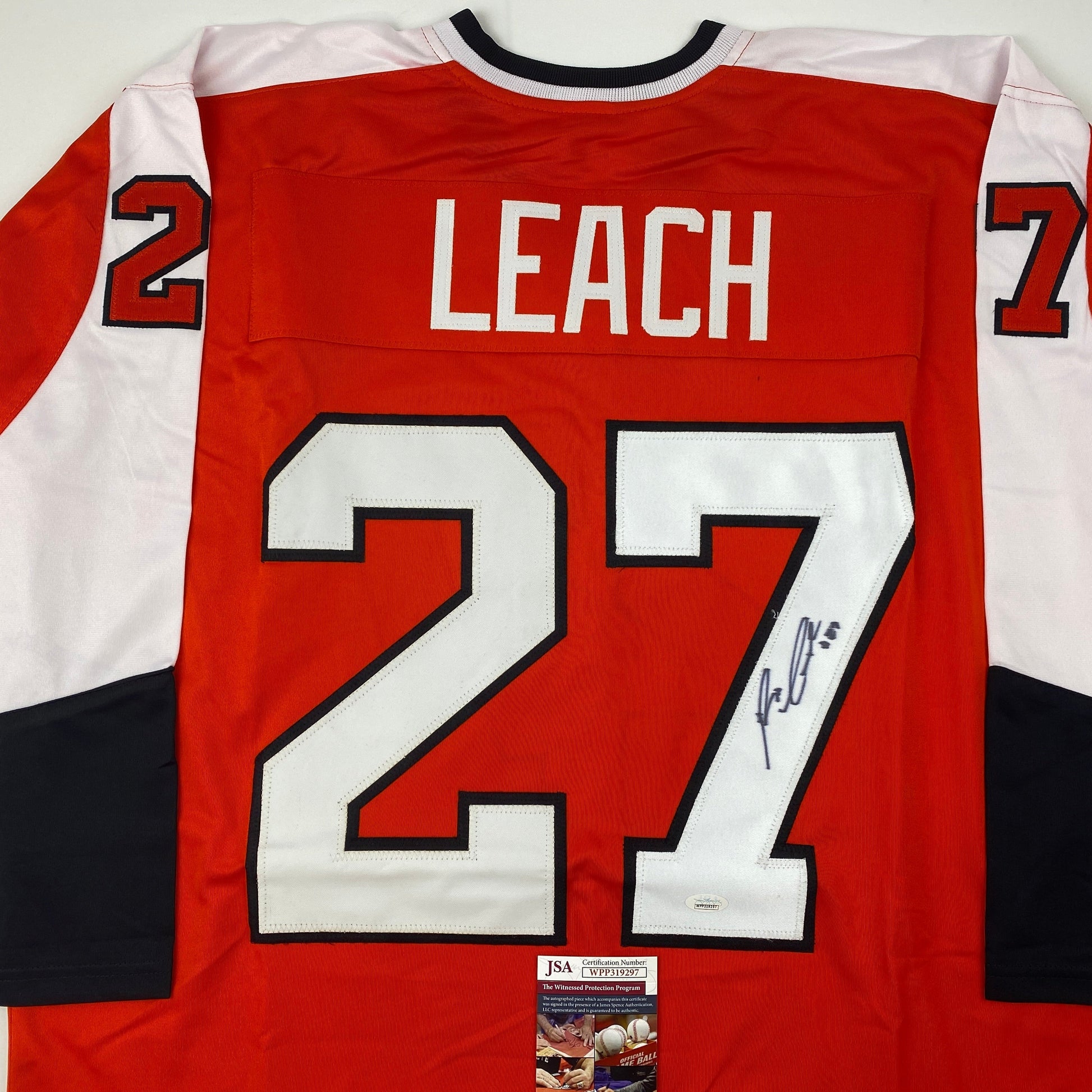 Back view of signed red Philadelphia Flyers hockey jersey #27 with "LEACH" nameplate and JSA authentication certificate visible.