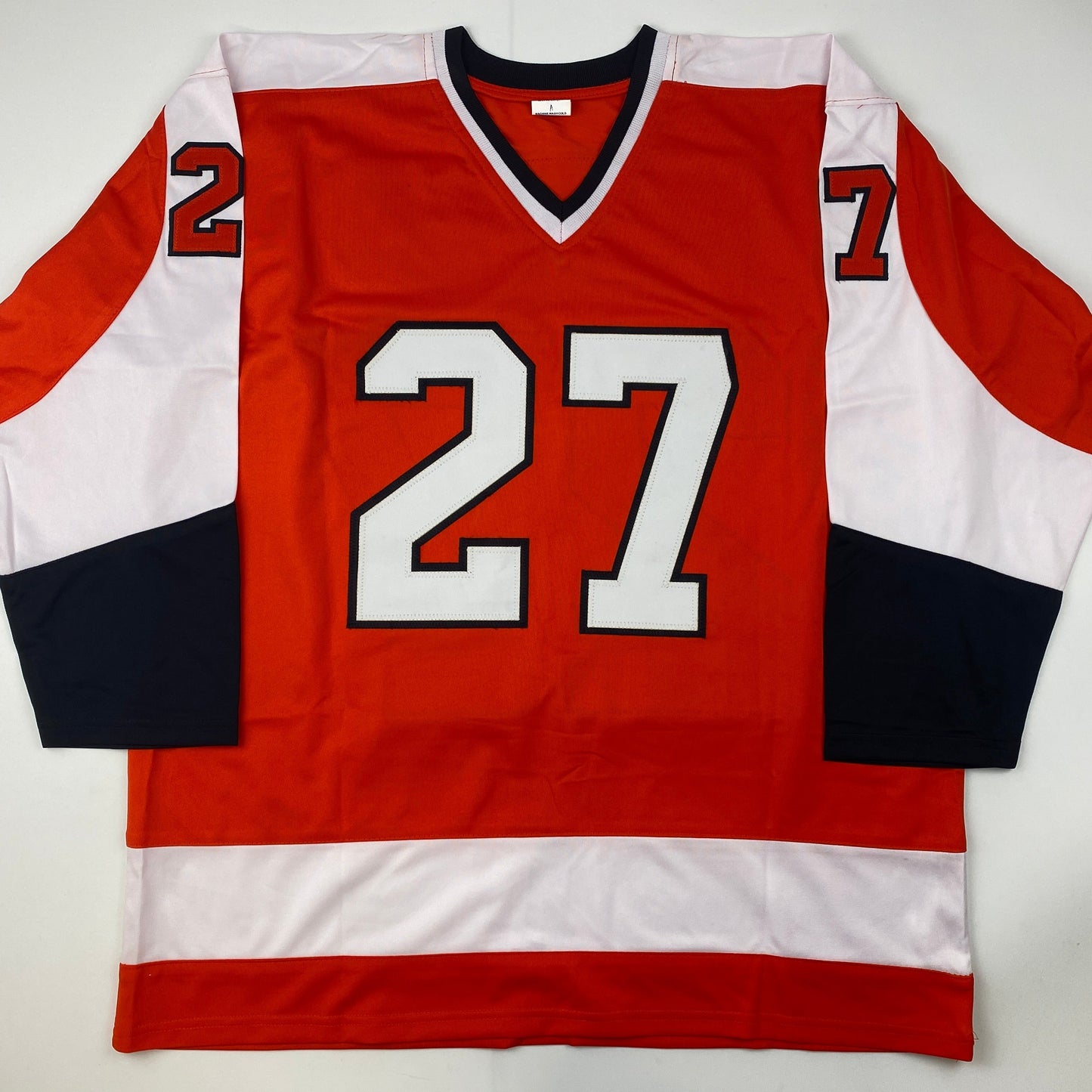 Red, white, and black striped hockey jersey with white number 27 displayed flat against white background.